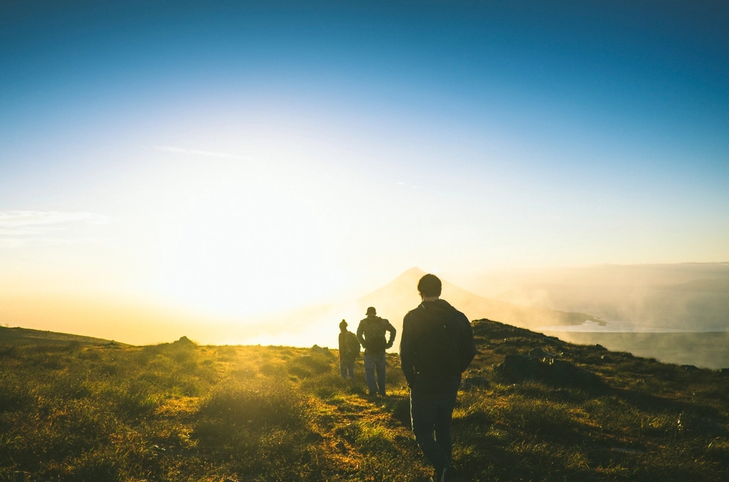 Three people hiking at sunrise in nature, symbolizing holistic health and lifestyle medicine in Virginia